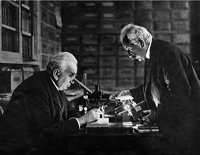 "Louis i Auguste Lumière za svojim radnim stolom, pioniri filmske industrije i izumitelji kinematografa."